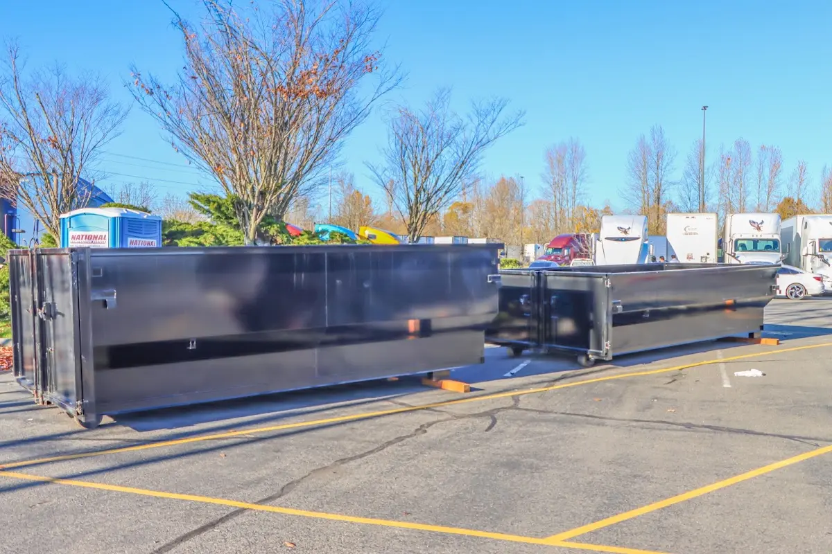 Professional dumpster rental service with roll-off container on residential driveway in Monterey